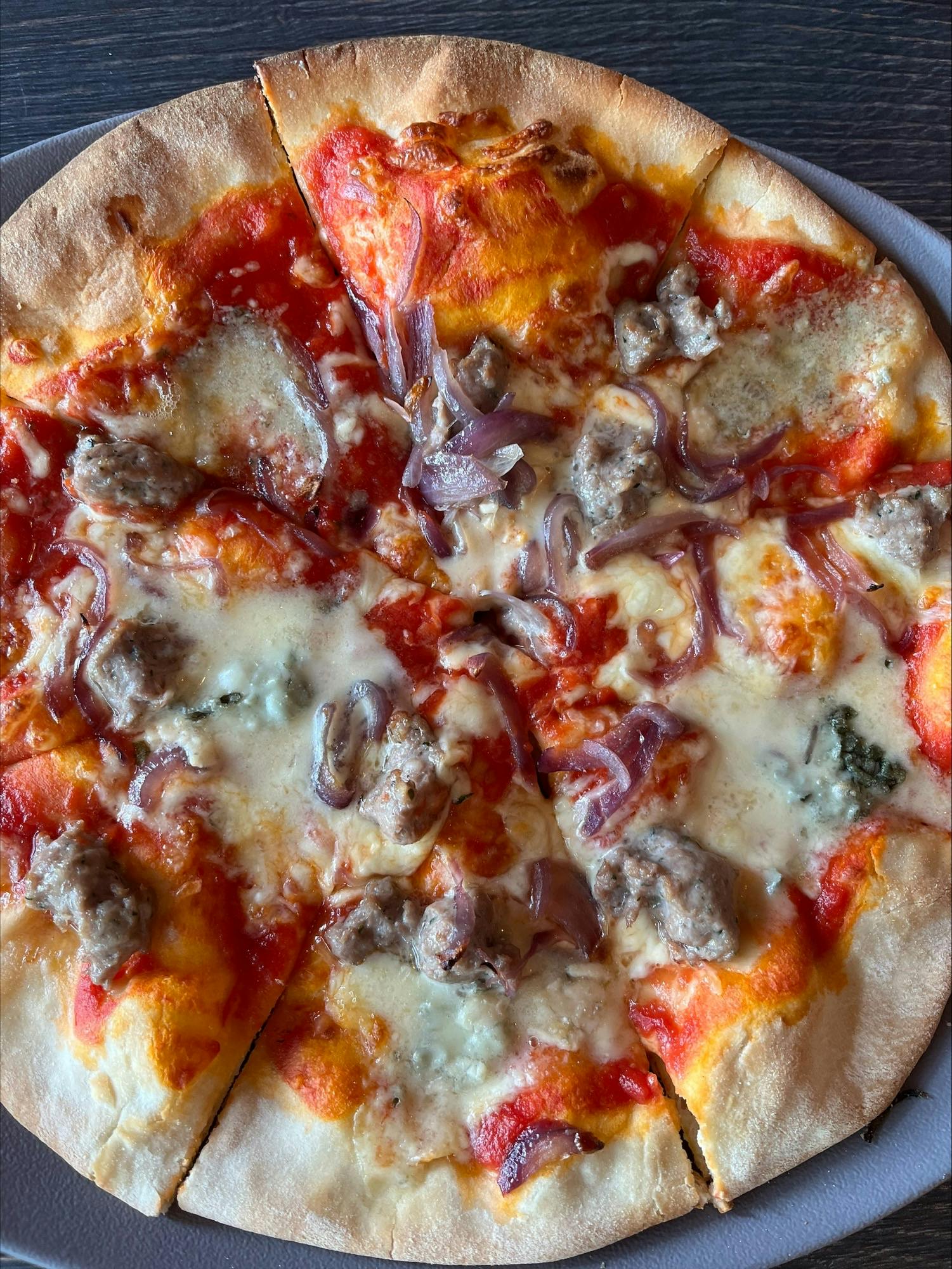 <p>Tomato sauce, roquefort, caramelized onions and sausages</p>